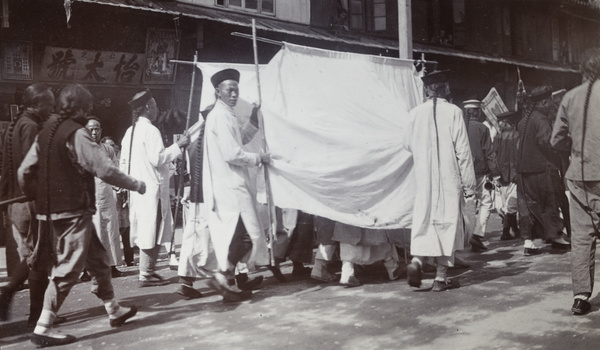  Mourners under a white canopy in a funeral procession, Shanghai