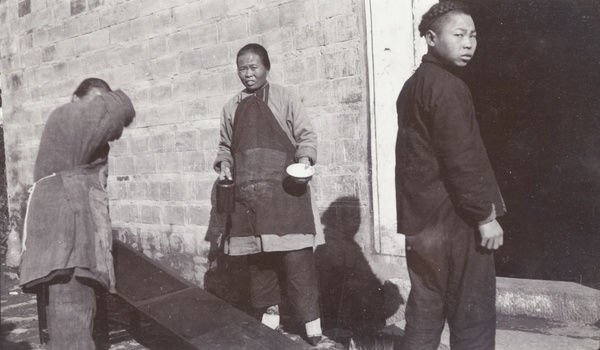 Two women wearing aprons and a young man
