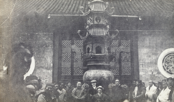 George Johnson, among others, beside an incense burner at an unidentified temple