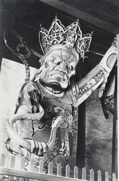 A shrine figure grasping a snake