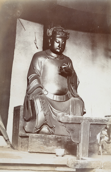 A shrine with Buddha holding a lotus flower