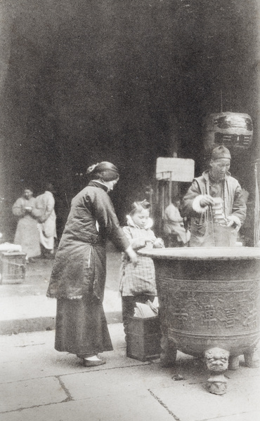 Placing paper offerings in a temple brazier