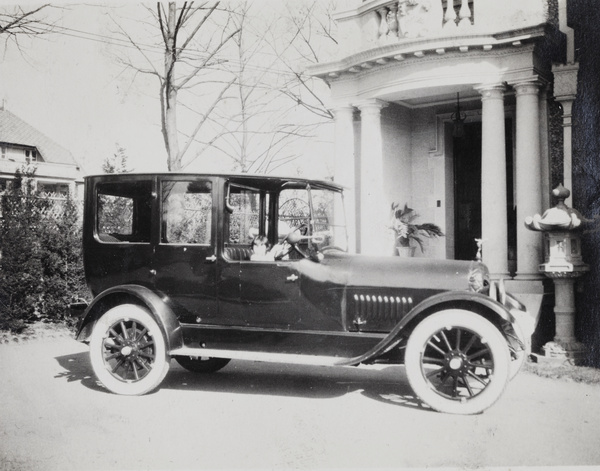 Wendy Johnson at the wheel of a car parked outside entrance of 727 Avenue Haig, Shanghai