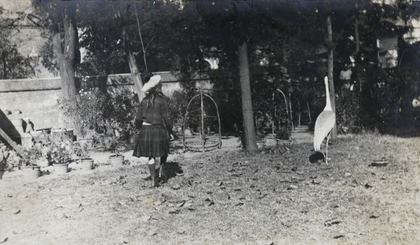 Gigi Detring in Commissioner's garden, Tientsin, with a crane