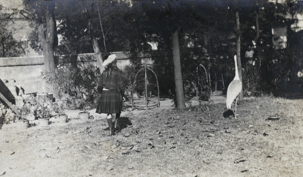 Gigi Detring in Commissioner's garden, Tientsin, with a crane