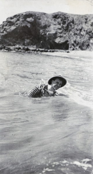 Reginald Hedgeland swimming at Qinhuangdao, wearing a pith helmet