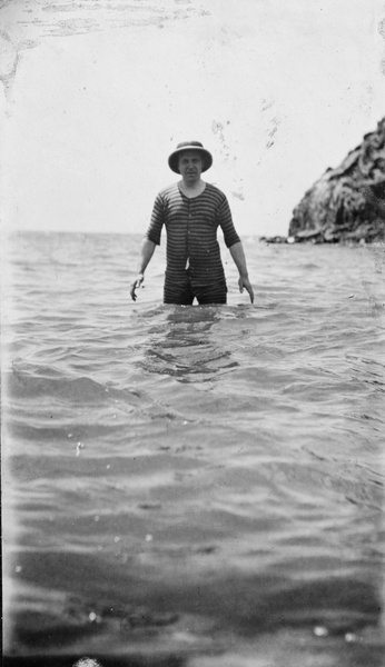 Reginald Hedgeland in the sea at Qinhuangdao, wearing a pith helmet