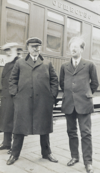 Trans-Siberian Railway passengers smoking on a platform