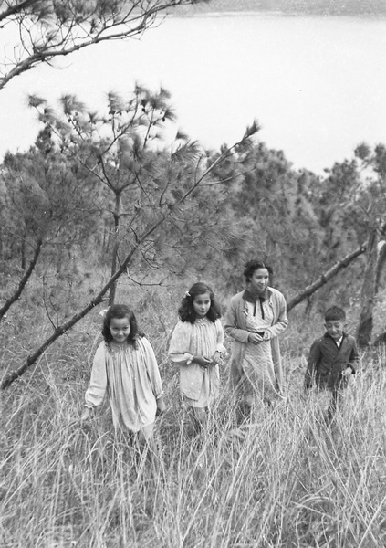 Kristine and Patricia Thoresen, an unidentified young woman, and Jim Hutchinson in a wooded area above a Castle Peak Road beach, Hong Kong