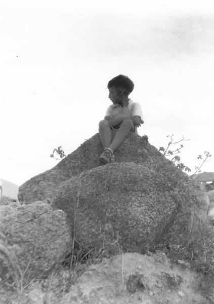 Jim Hutchinson sitting on a stony outcrop, near the Army Sports Ground, Mongkok, Hong Kong