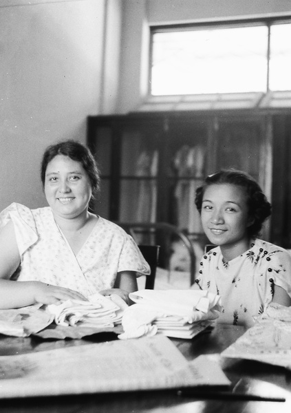 Sarah and Lucy Hutchinson, with a pile of table linen, Repulse Bay Hotel, Hong Kong