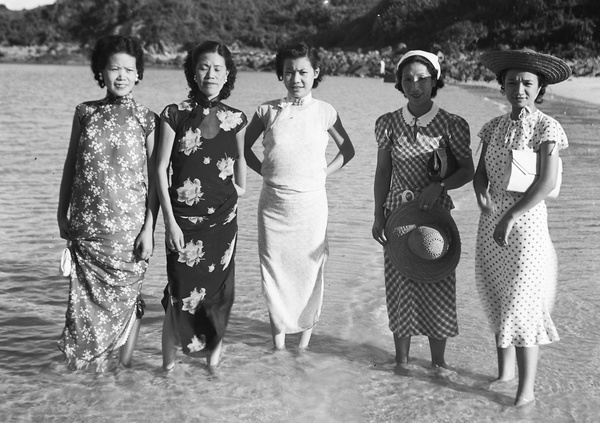 Unidentified wedding guests, Maggie Henderson and Lucy Hutchinson, ankle deep in shallow water at a beach, Hong Kong