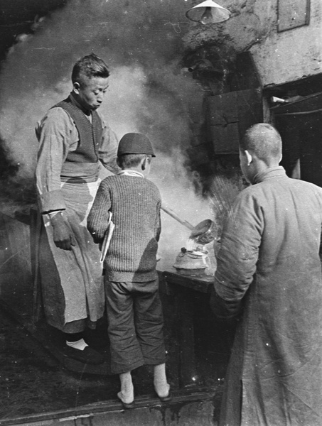 A man filling a kettle for a boy carrying a newspaper, in a hot water shop (old tiger stove shop or laohuzao), Shanghai