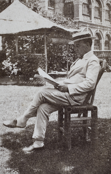 W. J. Terrill reading a newspaper in his garden, Tongshan Road, Hongkou, Shanghai