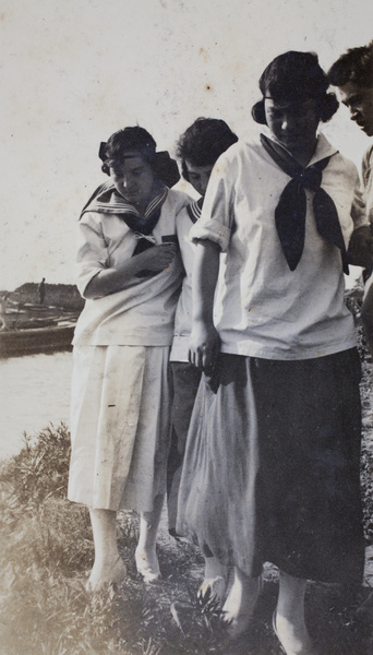Three young woman wearing sailor-style blouses walking near a river, Shanghai