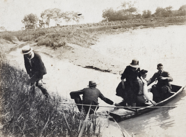 Woman stepping towards a river bank from a punt, Shanghai