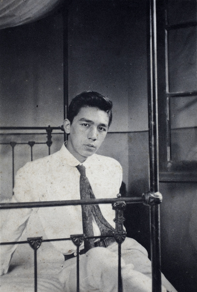 Bill Hutchinson sitting on his bed, 35 Tongshan Road, Hongkou, Shanghai