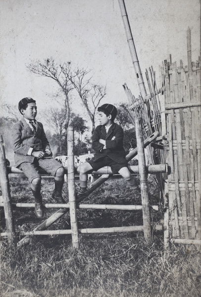 Dick and Fred Hutchinson sitting on top of a paddock fence, Hongkou, Shanghai