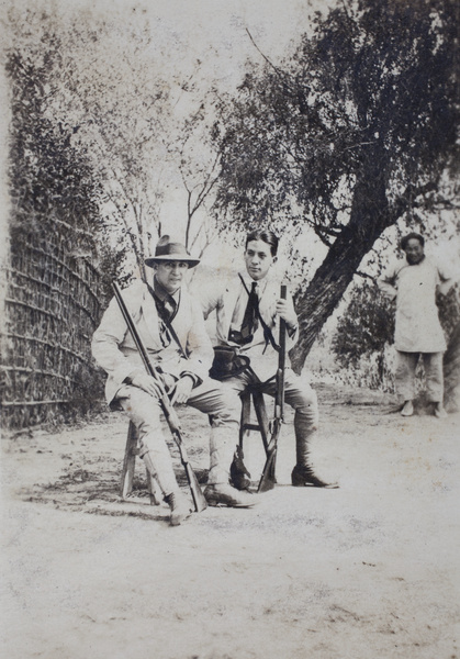 Charles Hutchinson and John Piry sitting on a trestle with hunting rifles, Shanghai