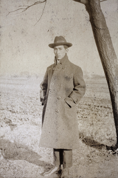 Tom Hutchinson wearing an overcoat, standing beside Tongshan Road, Hongkou, Shanghai