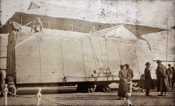 Onlookers watch an Italian aviation team preparing for the transportation of a 'Raid Rome-Tokyo' relay biplane, Shanghai