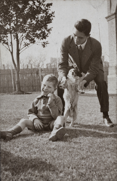 Bill Hutchinson playing with a dog and neighbouring boy, 35 Tongshan Road, Hongkou, Shanghai