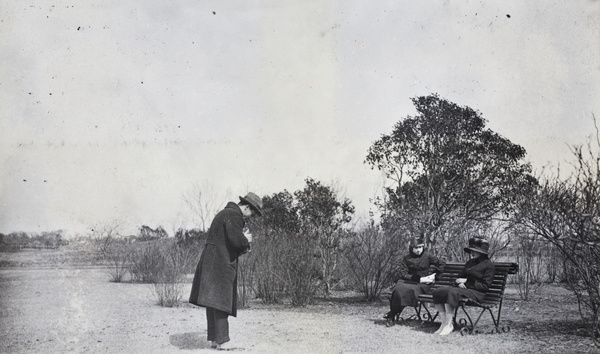 John Piry photographing two young women sitting on a bench, Jessfield Park, Shanghai