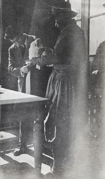 William Hutchinson inspecting a chicken held by a Chinese man, 35 Tongshan Road, Hongkou, Shanghai