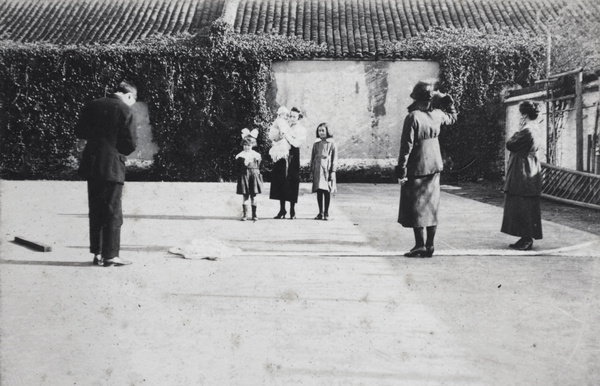 Tom Hutchinson taking a photograph while two women look on, Shanghai