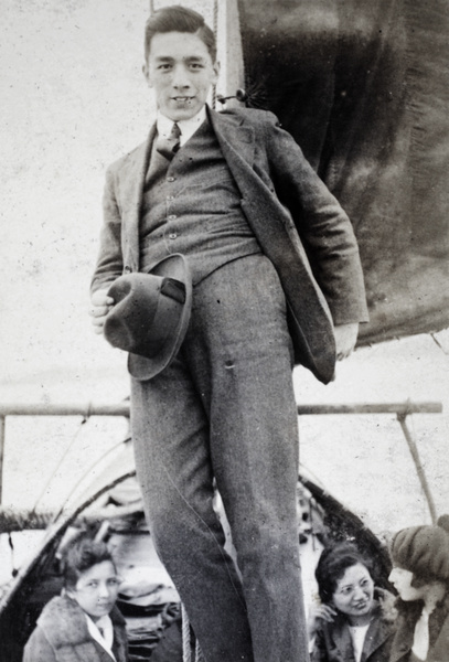 Bill Hutchinson leaning against the sail mast of a river boat, Shanghai