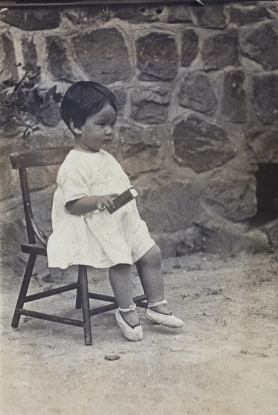 Bea Hutchinson holding a small box and sitting on a wooden chair, Moganshan
