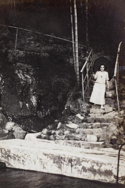 Margie Hutchinson walking down the steps to an open air swimming pool, Moganshan