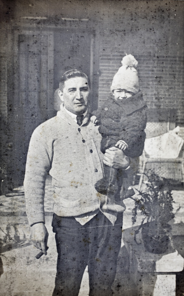 Charles Hutchinson, a cigar in one hand, holding up Sonny with his other arm, 35 Tongshan Road, Hongkou, Shanghai