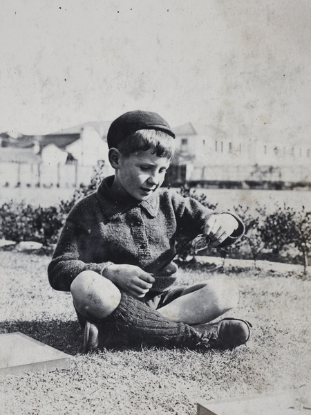 A boy holding an object in the garden, 35 Tongshan Road, Hongkou, Shanghai