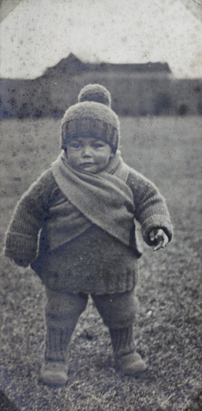 Unidentified toddler wearing handknitted clothing in the garden, 35 Tongshan Road, Hongkou, Shanghai