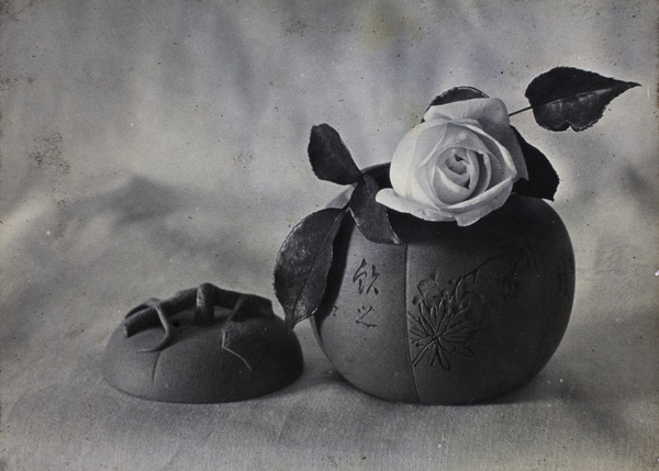 Still life with a rose flower in a pumpkin-shaped pot