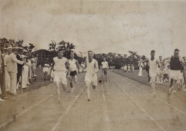 Referees and spectators watching runners cross the finish line at a 4th of July sports day, Shanghai, 1922