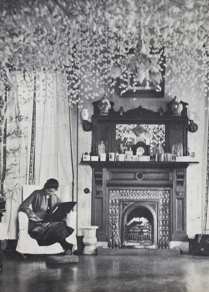 Sarah Hutchinson looking at a photograph album in the living room decorated with threaded popcorn, 35 Tongshan Road, Hongkou, Shanghai