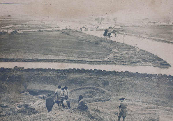 Group of friends walking down a hill towards the old city wall and river, Kunshan