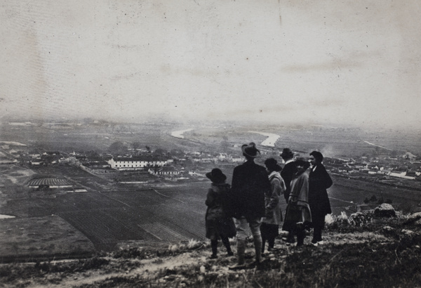 Maggie Hutchinson and John Henderson standing with friends on the old city wall looking across a river plain, Kunshan