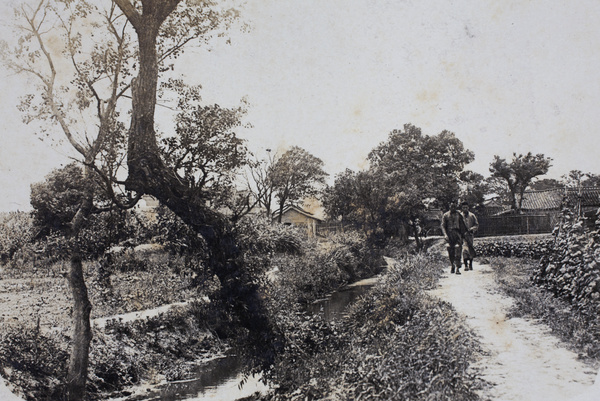 Two men walking beside a waterway along the undeveloped section of Tongshan Road, Hongkou, Shanghai