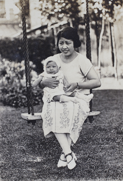 Georgina Kirby sitting on the garden swing holding her baby daughter, 25 Tongshan Road, Hongkou, Shanghai