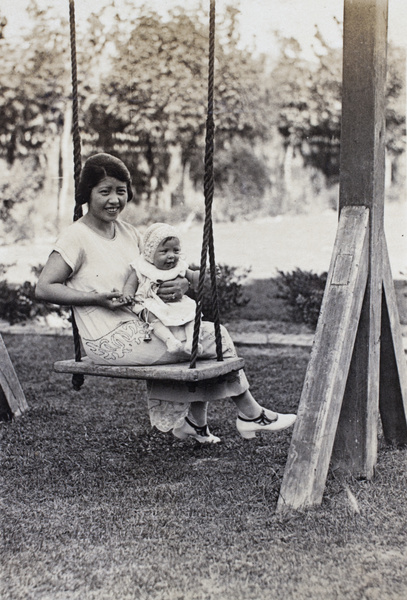 Georgina Kirby sitting on the garden swing holding her baby daughter, 35 Tongshan Road, Hongkou, Shanghai