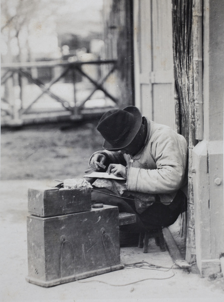 Plate mender at work in the street, Shanghai