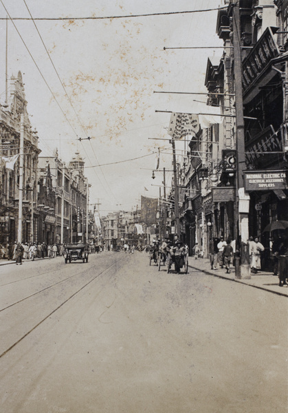 Shops, pedestrians, rickshaws and a motorcar on Nanjing Road, Shanghai, 2 June 1925