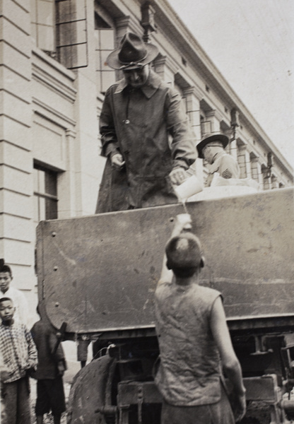 American Company Shanghai Volunteer Corps handing out rations of rice near the Huasing Road tram sheds, Shanghai, 1925