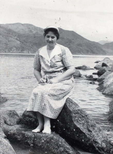 Sarah Hutchinson sitting on the rocks of a bay, Hong Kong