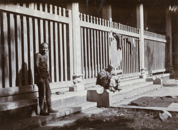 Buddhist priest mending clothing in temple courtyard, Canton