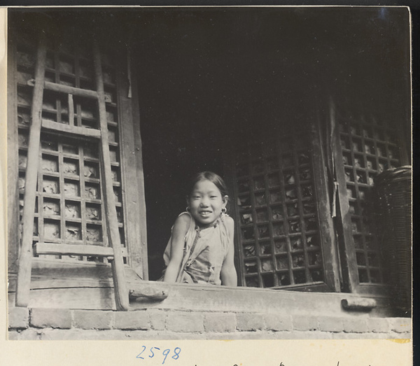 Girl with earrings looking out a window in the Lost Tribe country