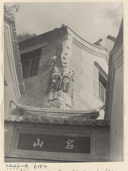 Detail of entrance gate to the Sheng mi zhi tang Monastery showing inscription, two relief figures with a lotus, and bats